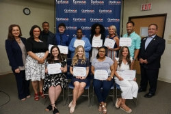 Kelsey Soileau, Lyndsy Hester, Chassidy Watson and Tessie Rideaux. Pictured standing from left: Gina Tuttle, Chairman of the Board of Trustees, Tracey Antee, Foundation Director, Pierre Dupre, Carson Doyle, Amy rosette, Ashley Warner, Kristie Manuel, Perry Kennerson and Ken Cochran, President & CEO